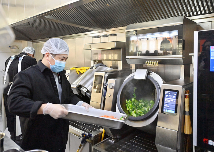 九游娱乐：锅圈的新店打算让机器人来炒菜(图1)
